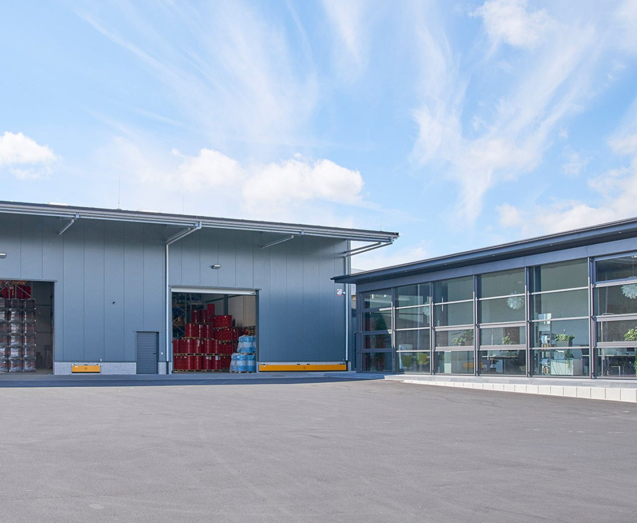 Ansicht zweier Lagerhallen vor blauem Himmel.
