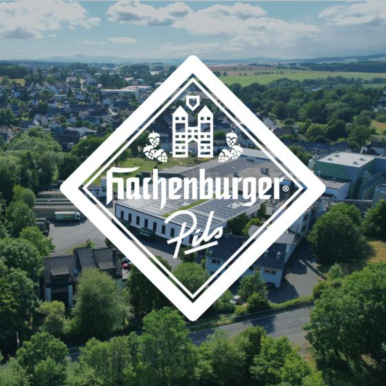 Logo vor einer Luftaufnahme von einer Halle mit Solardach.